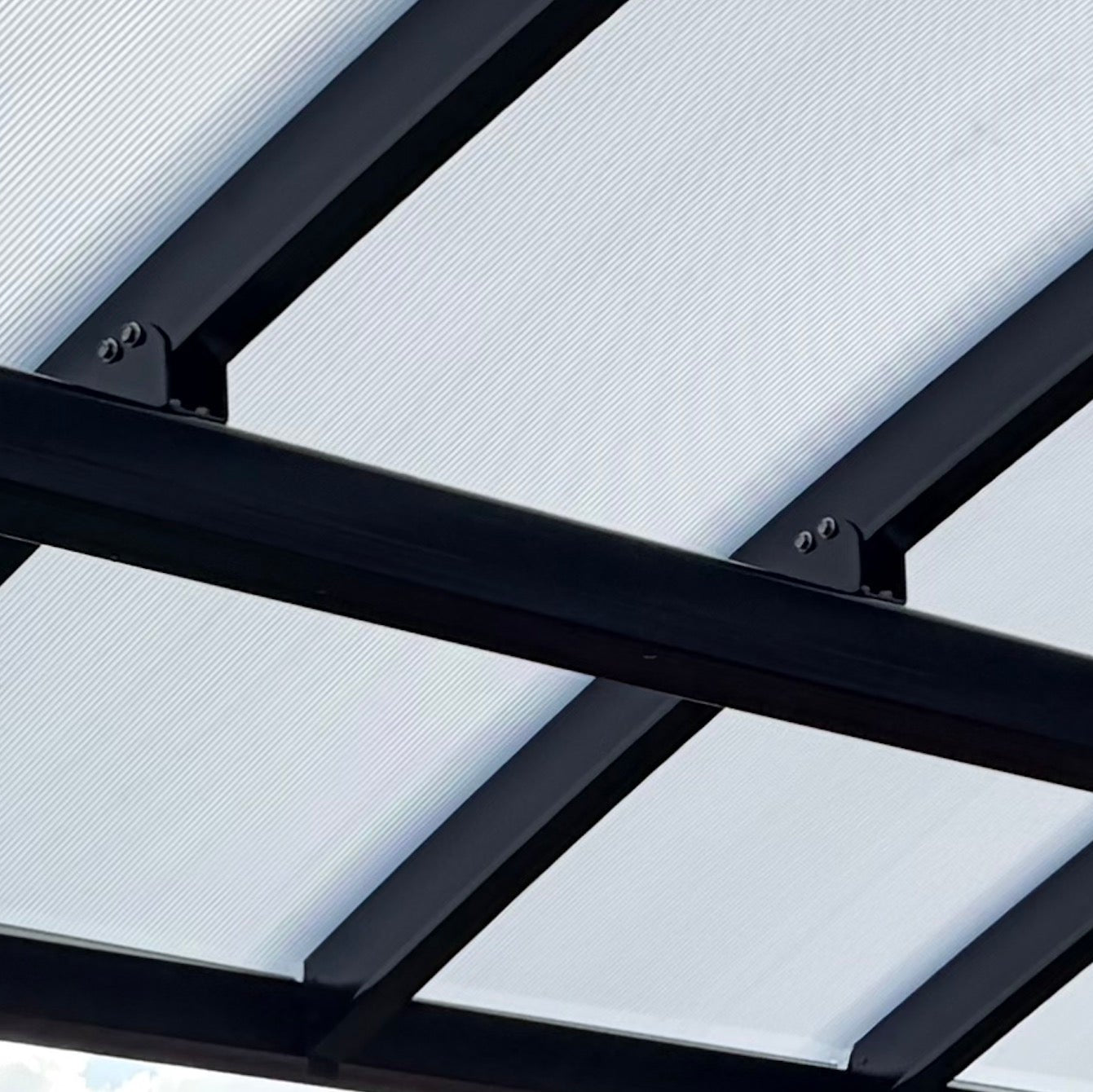 Close-up of a modern canopy or pergola frame with black metal beams, saddle brackets, and translucent white panels.