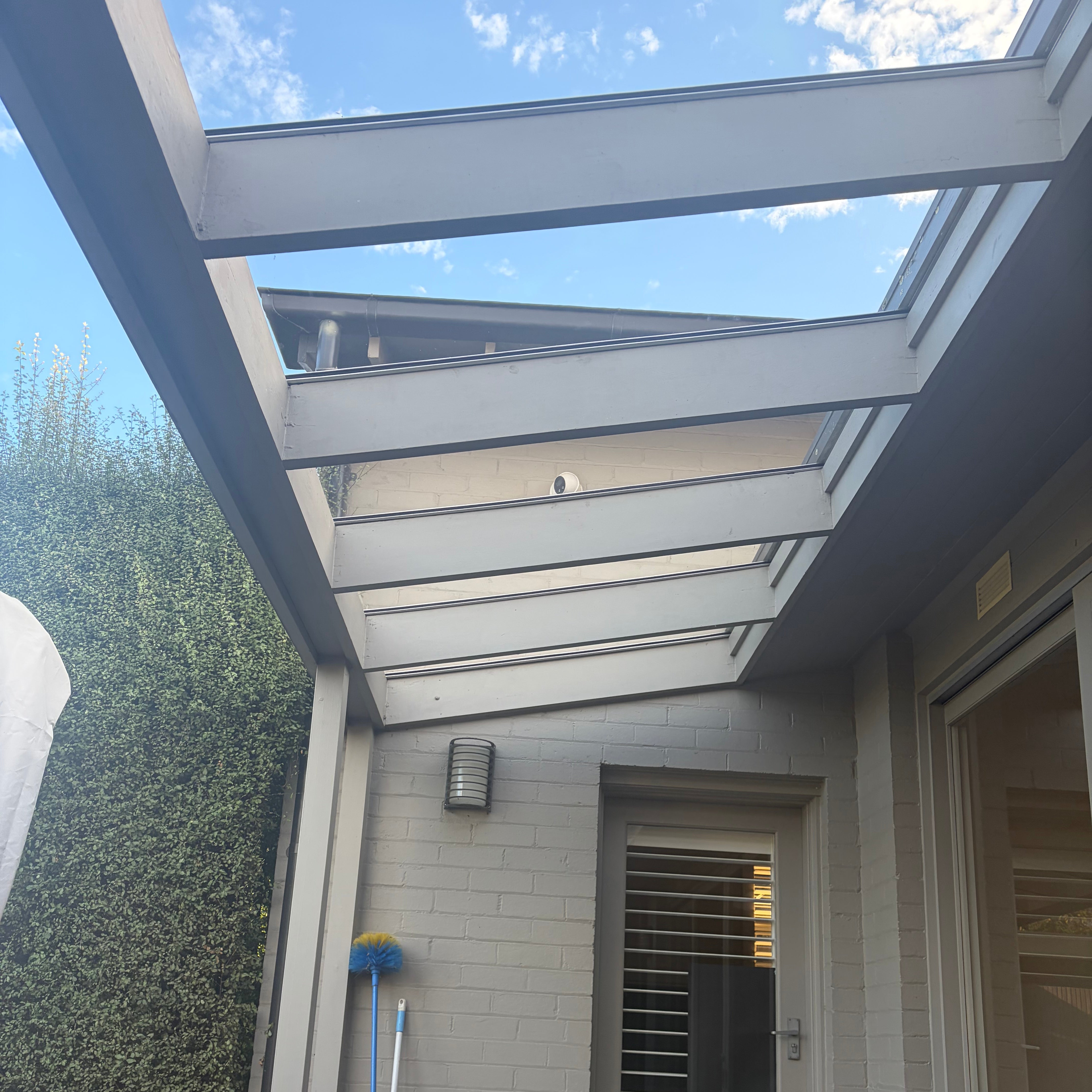 A modern glass-like patio canopy covered by polycarbonate solid flat sheet and used aluminium H joiner to connect.
